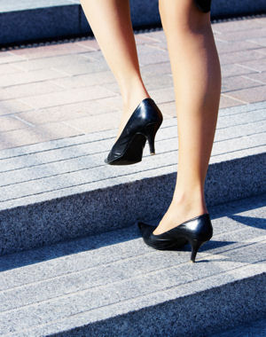 Businesswoman taking step to higher level on stairway