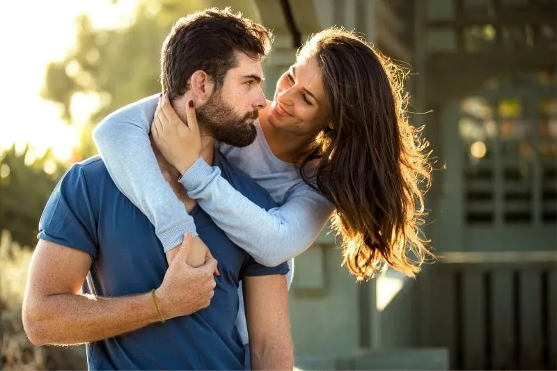 sweet woman hugging a handsome man outdoors