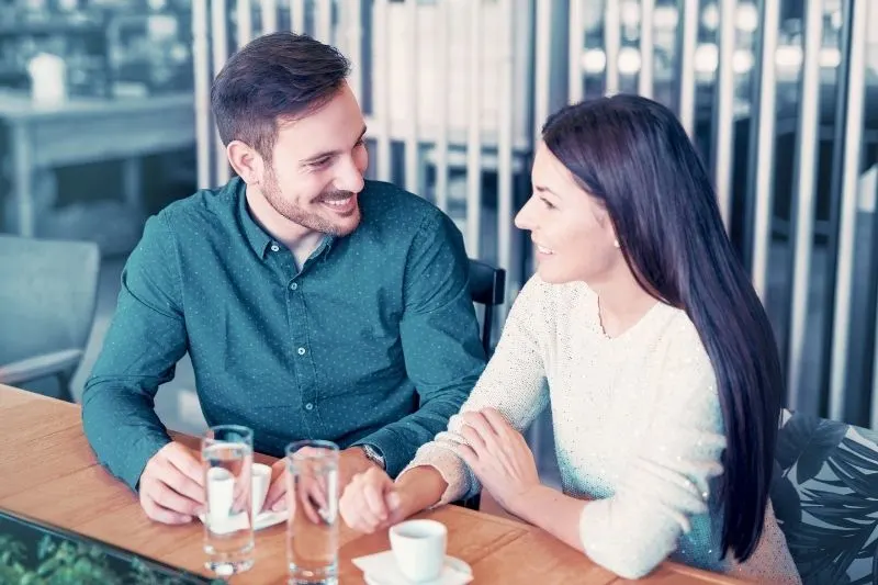 smiling man having coffee in an outdoor cafe